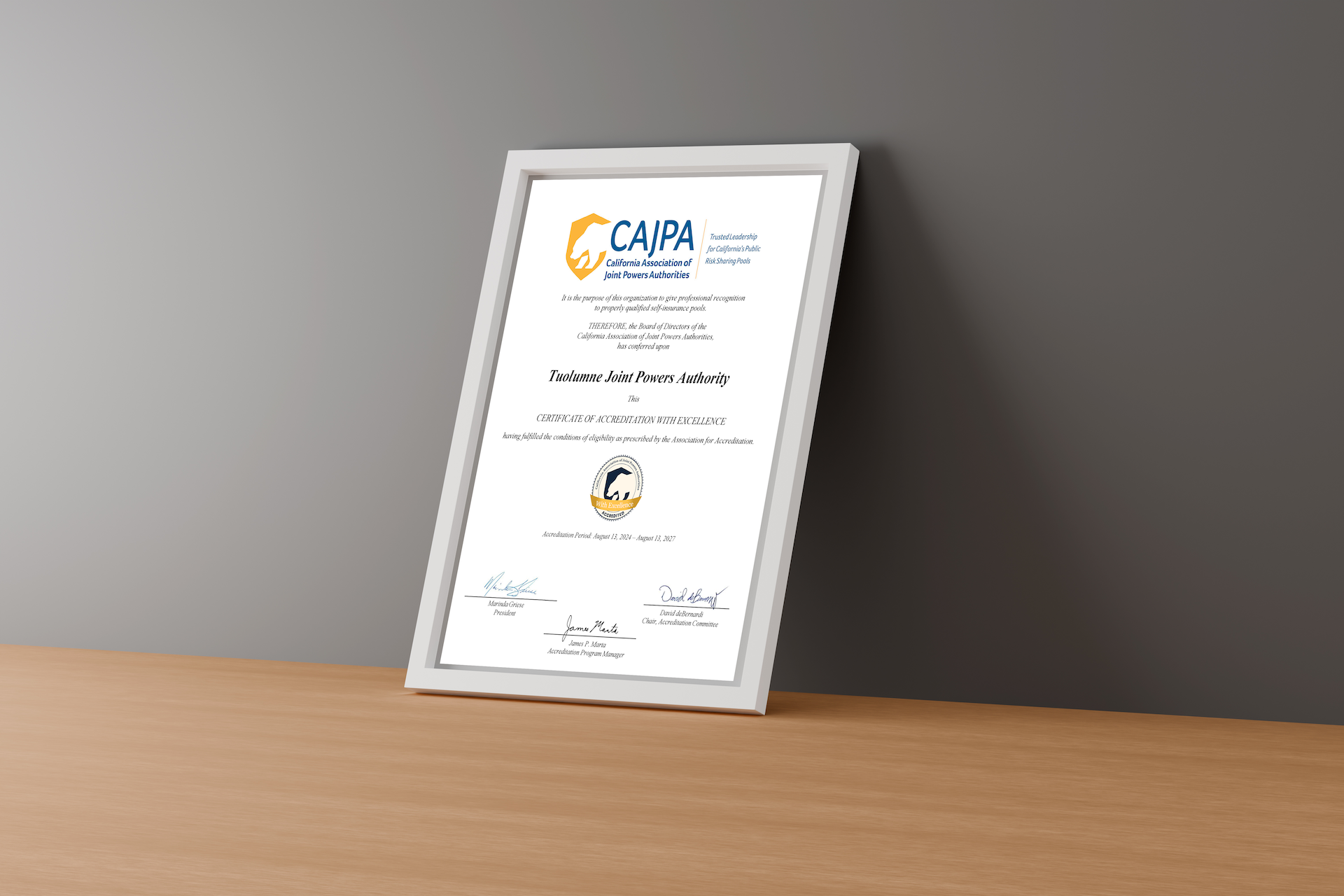A framed CAJPA Accreditation Certificate for Tuolumne Joint Powers Authority displayed on a wooden desk against a neutral background.
